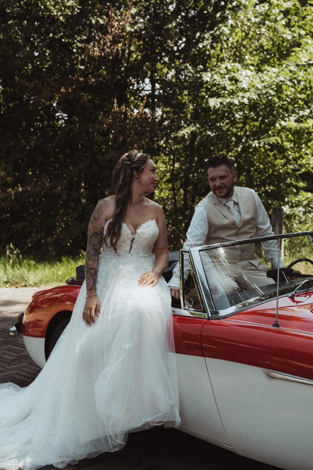 Bruidspaar bij een rode oldtimer