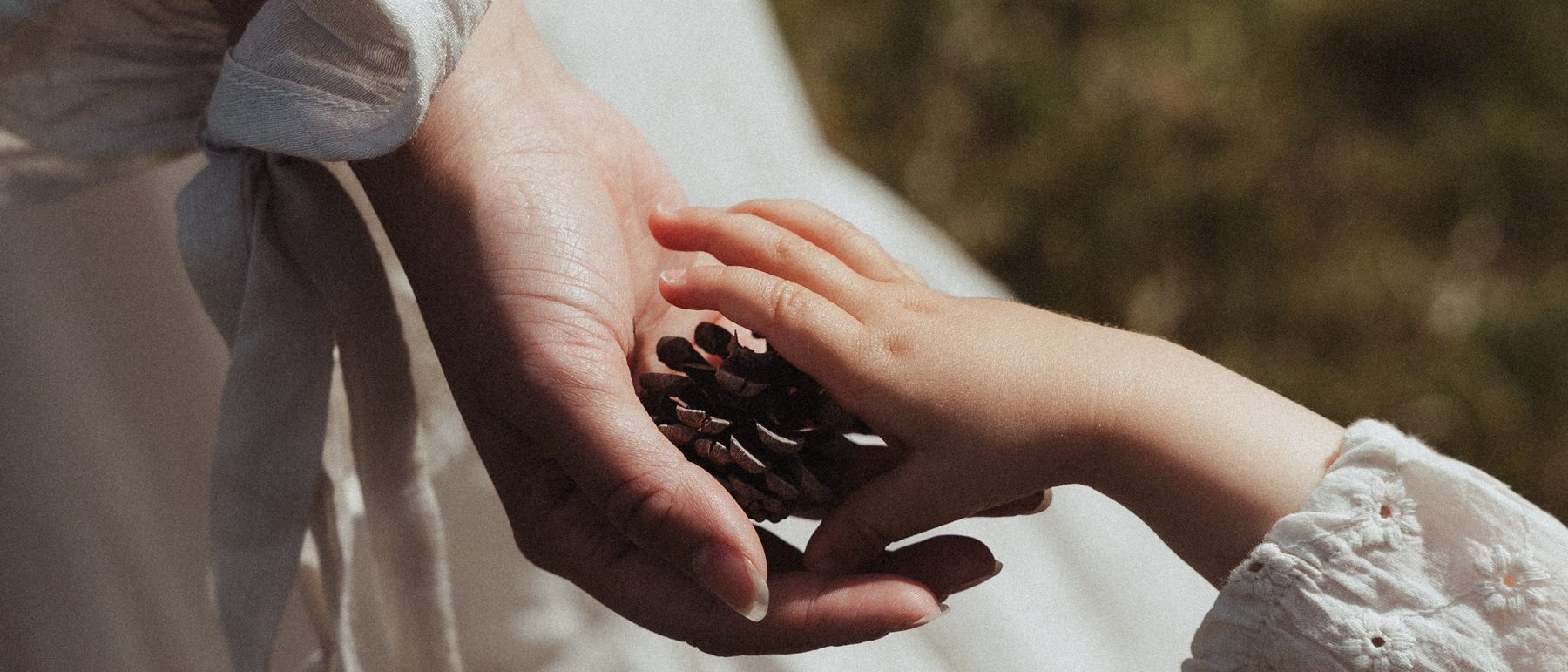Kinderhand legt steentjes in de hand van haar moeder