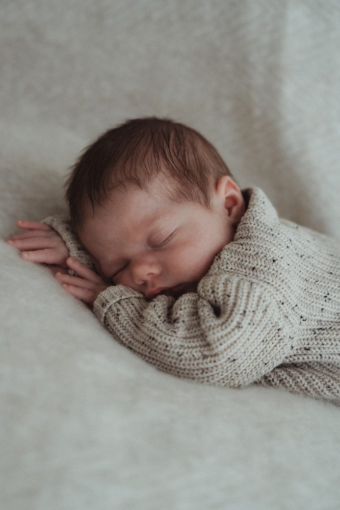 Slapende newborn in gebreid pakje